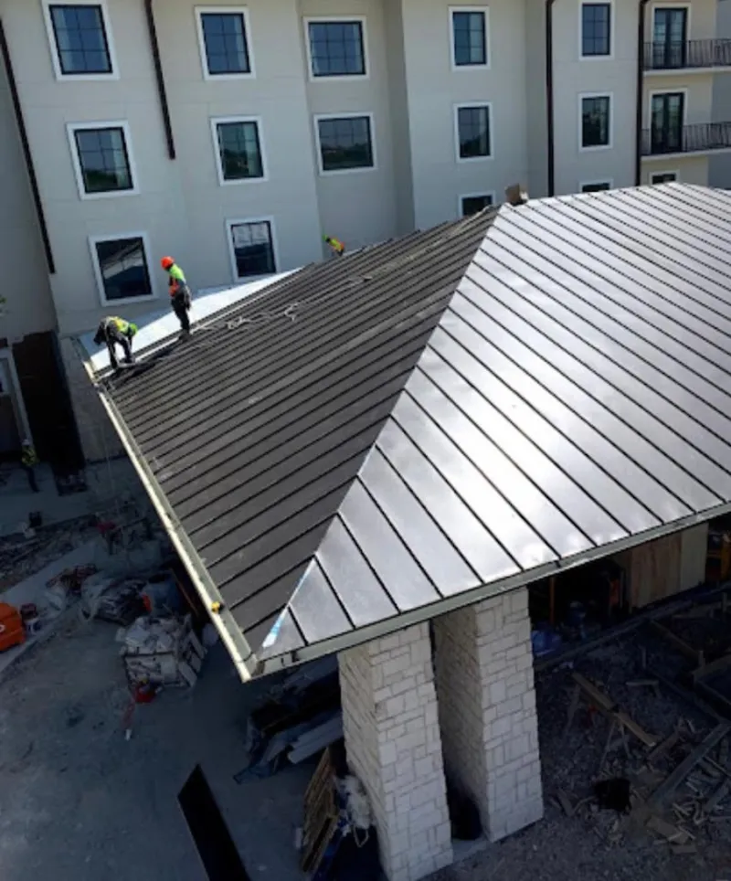 Crew installing standing seam metal roof panels on a commercial project in Floral City